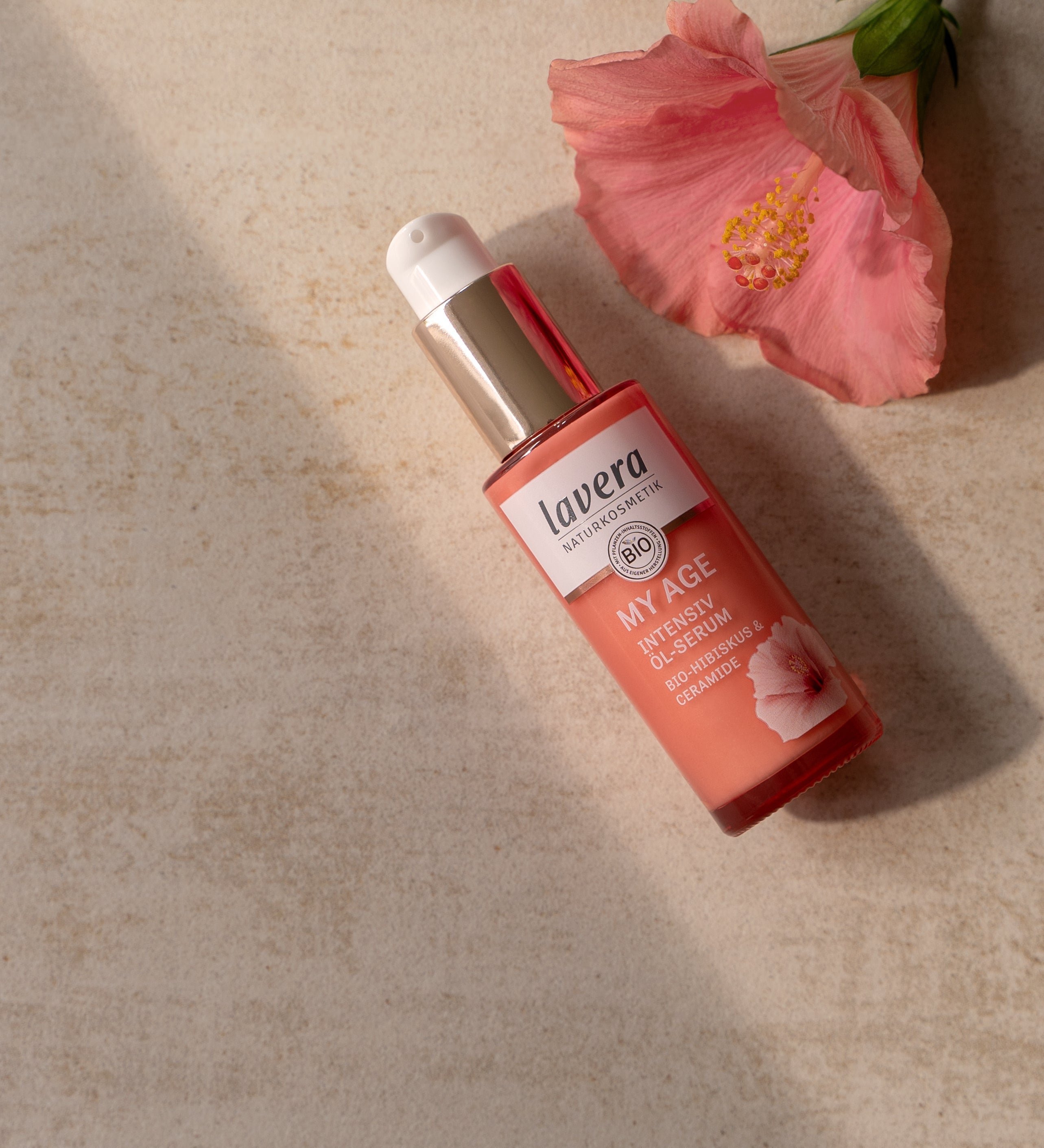 lavera My Age Intensive Oil Serum with Hibiscus Blossom on a light background.