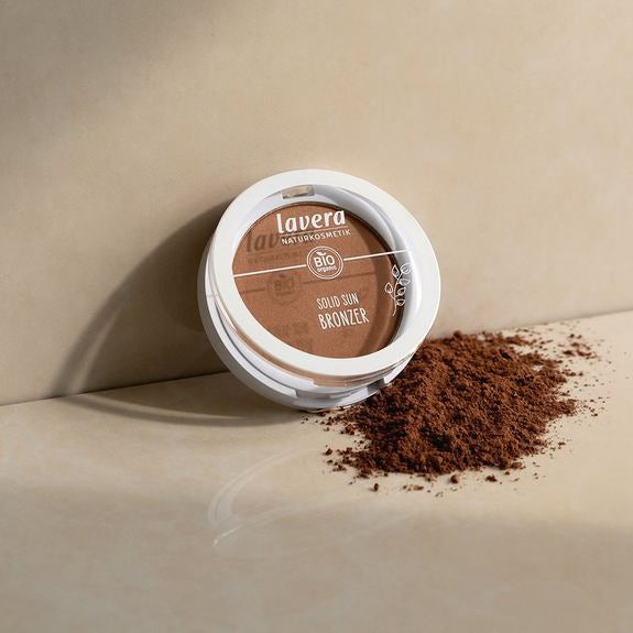 Geöffneter lavera Solid Sun Bronzer mit Puder auf beiger Fläche