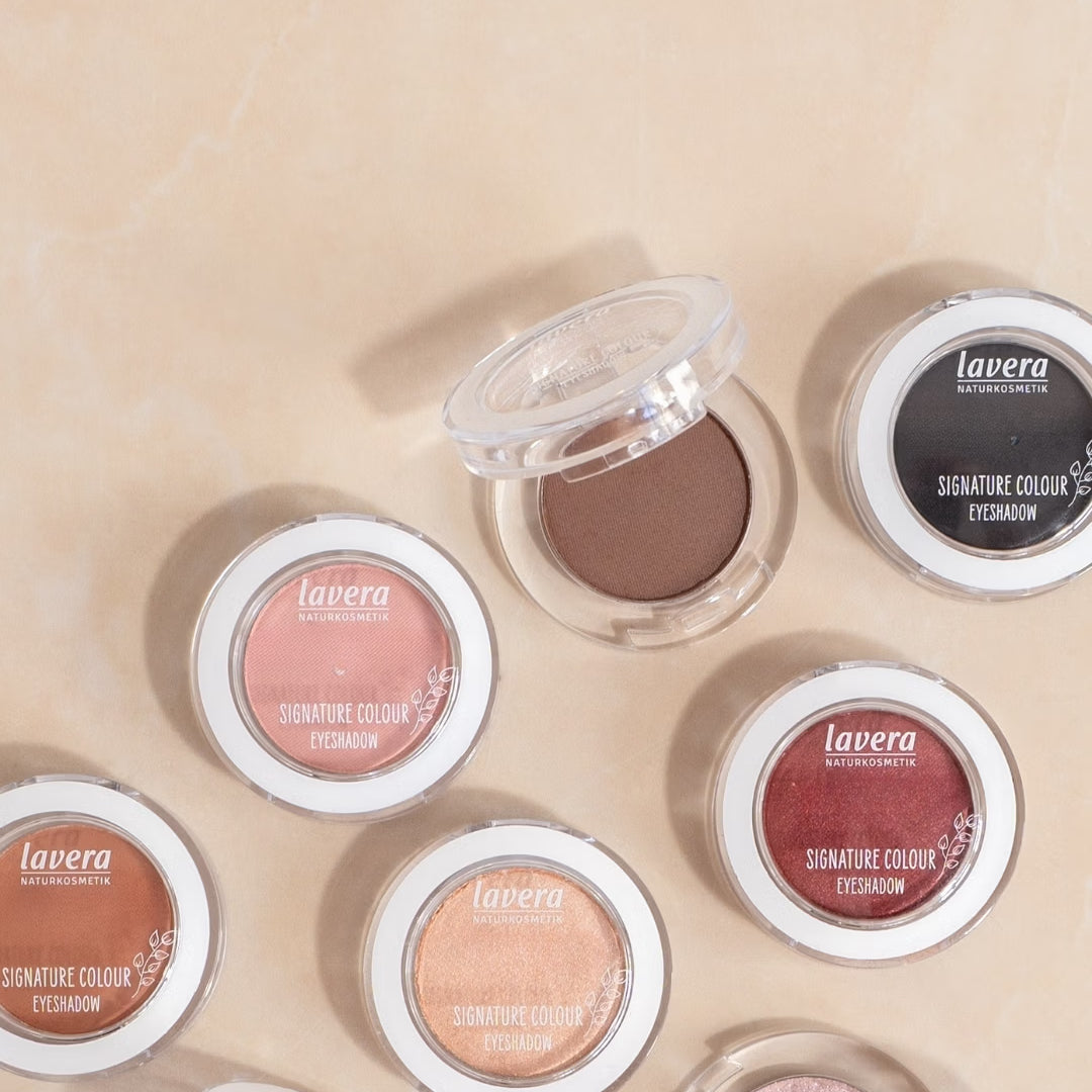 lavera Signature Colour eyeshadows in various shades lie on a light, marbled surface.