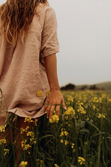 Frau von hinten im Feld mit gelben Blüten