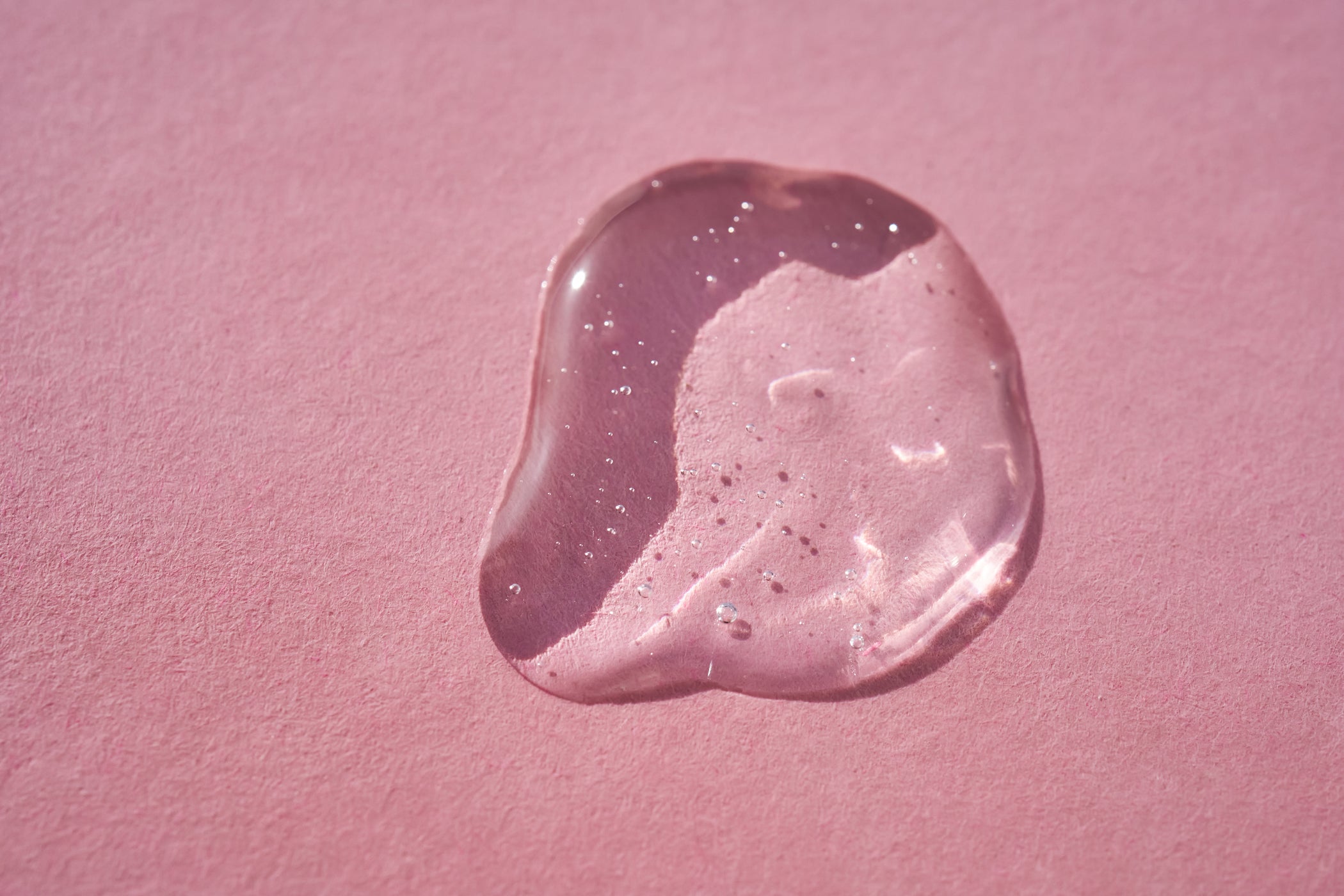 Geltropfen durchsichtig auf pinken Untergrund