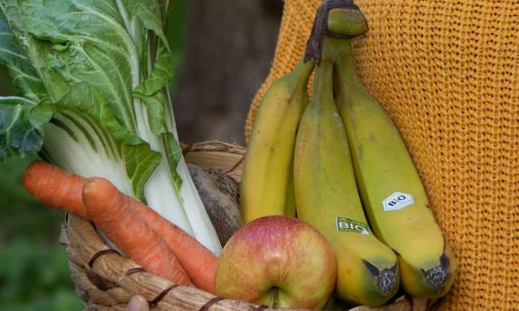 Korb mit Bananen, Apfel, Karotten und Mangold