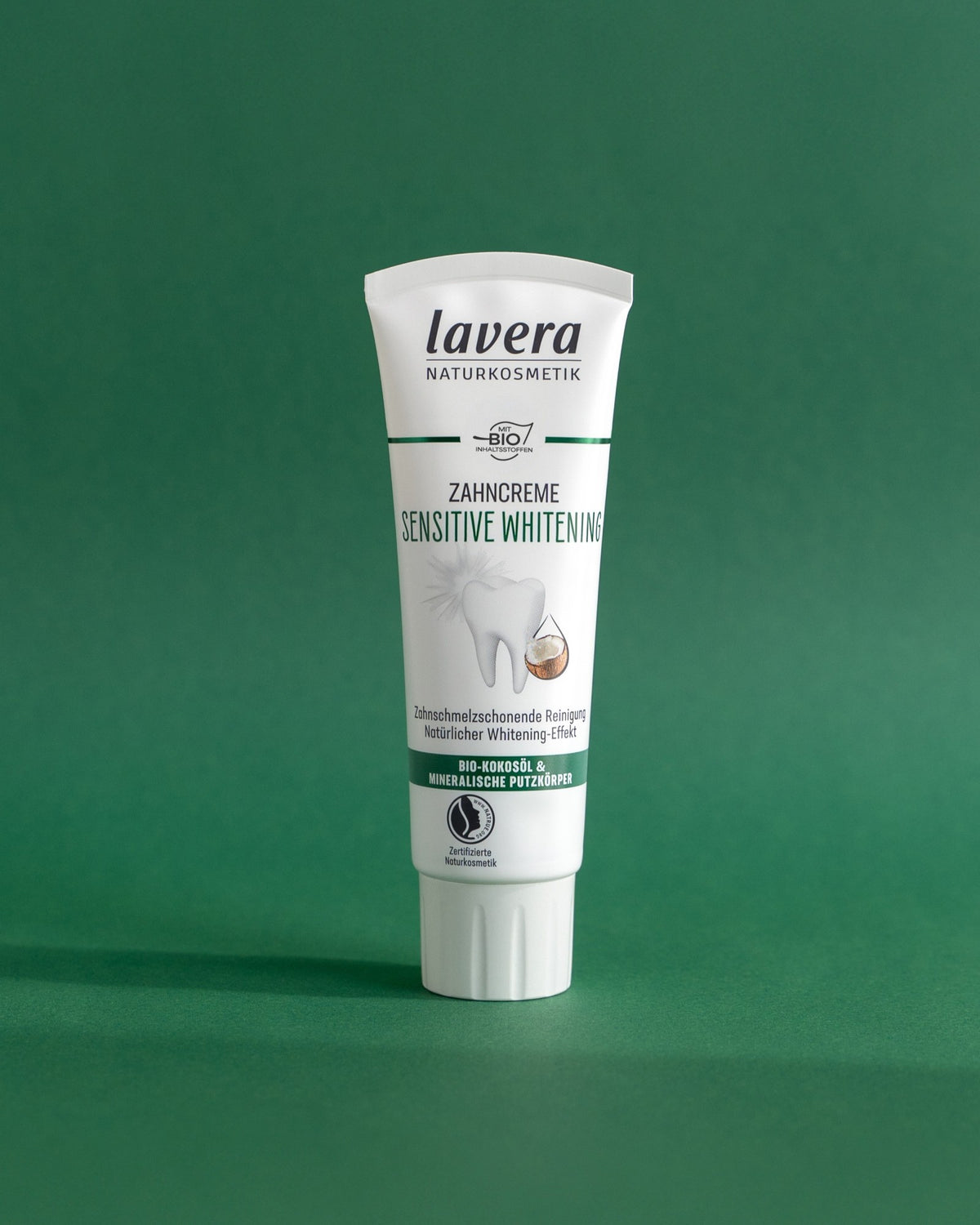 lavera Sensitive Whitening toothpaste against a green background
