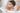 Baby in der Wanne guckt raus Mutter im Hintergrund waescht das Baby