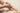 Der Arm eines Babies wird gehalten und mit der anderen Hand das Baby massiert. 