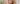 A blonde woman with subtle makeup looks directly into the camera and presents the Radiant Skin Concealer from lavera natural beauty