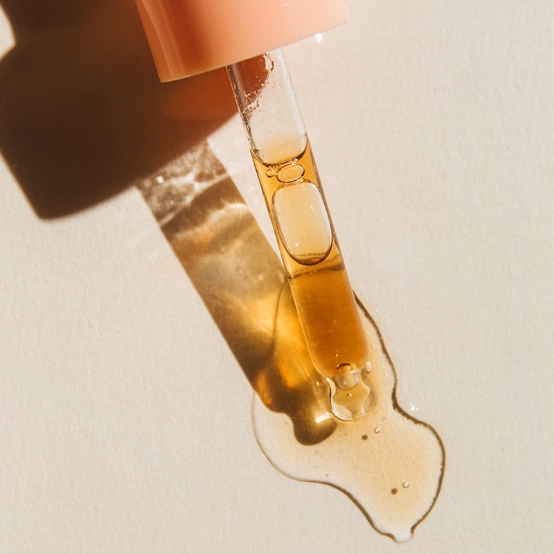 pfirsichkernoel_pipette_inhaltsstoffe pipette mit hellgelbem oeltropfen auf hellem untergrund
