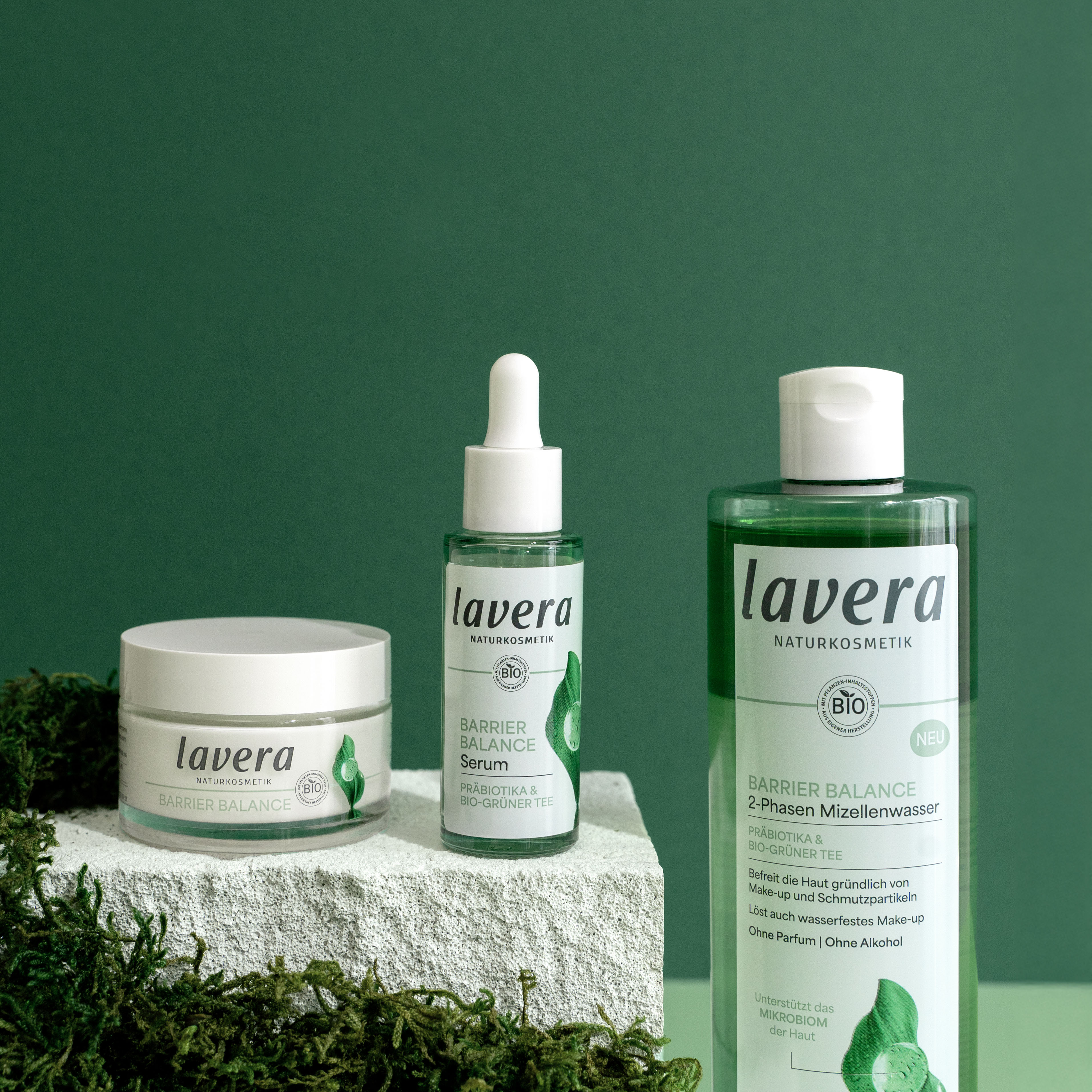lavera Barrier Balance Produkte Drei lavera Barrier Balance Produkte vor grünem Hintergrund.