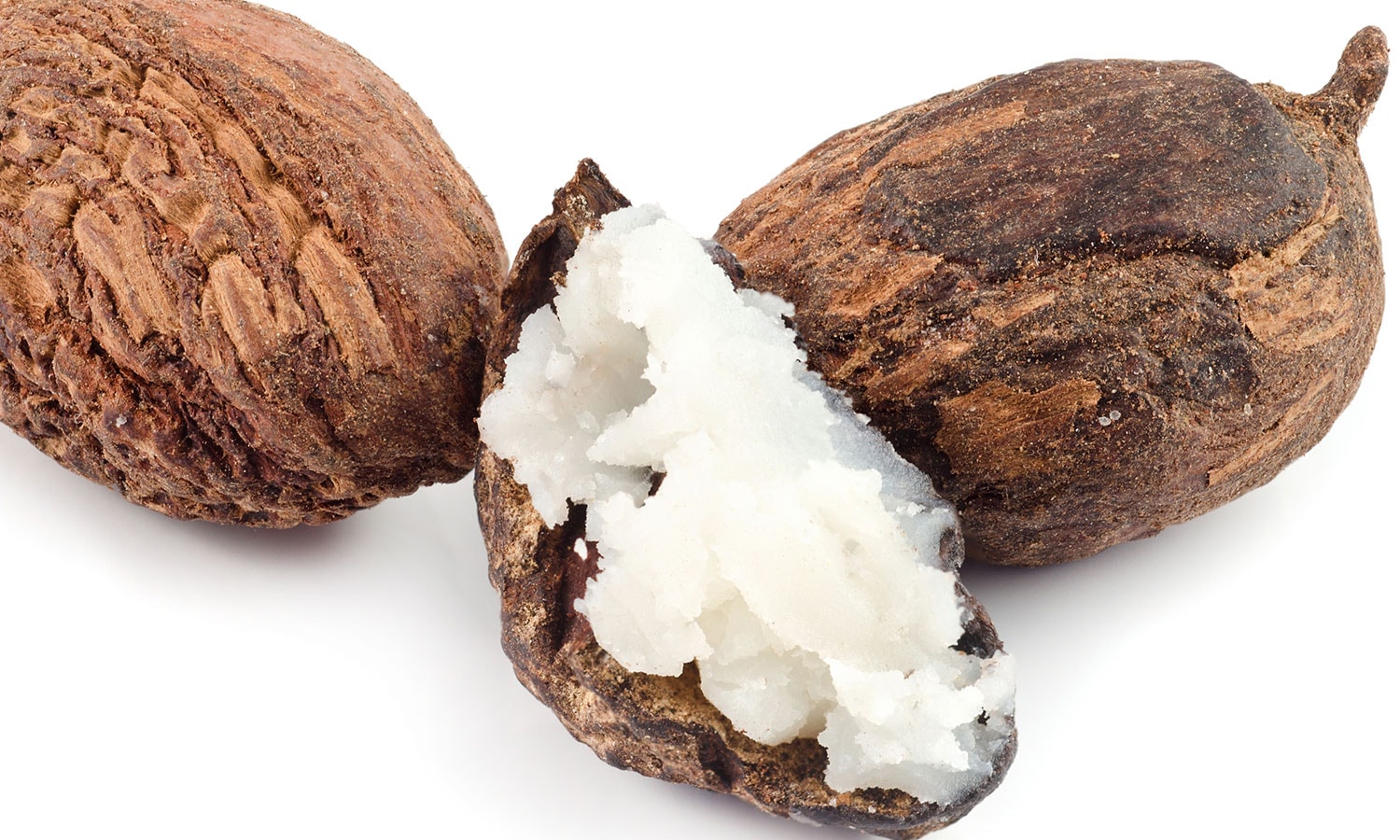 Trois noix de karité, dont l’une est ouverte, laissant apparaître le beurre de karité blanc à l’intérieur.