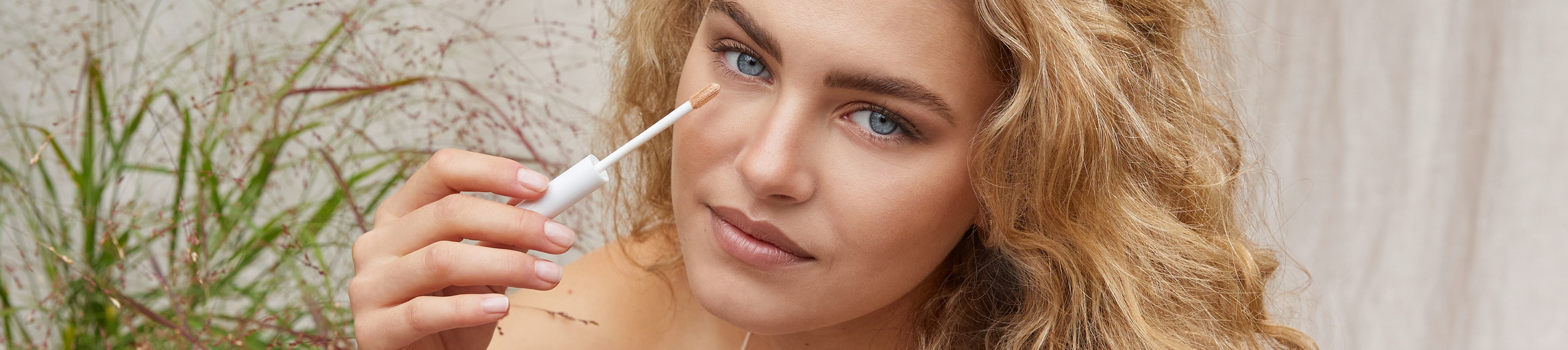 Make up lavera Naturkosmetik A blonde woman with subtle makeup looks directly into the camera and presents the Radiant Skin Concealer from lavera natural beauty